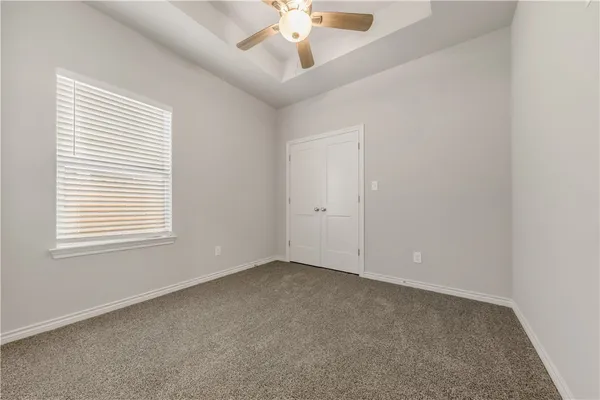 an empty room with a window and a ceiling fan