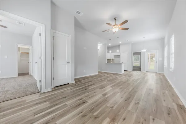 a view of an empty room and kitchen view