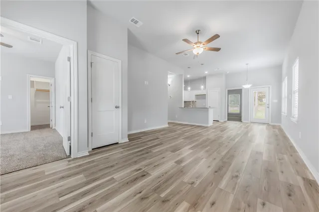 a view of an empty room and kitchen view