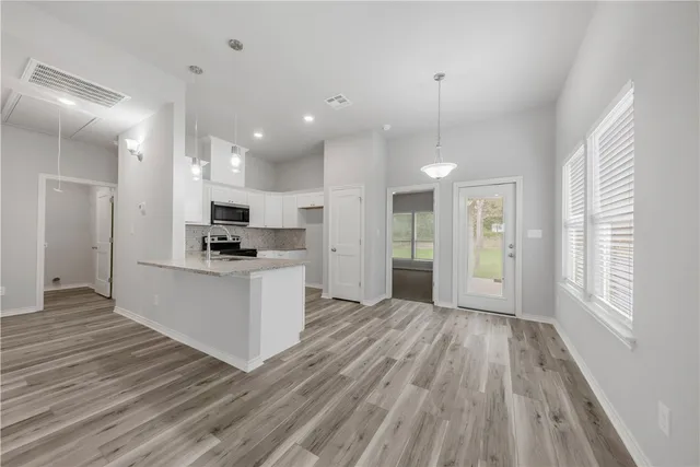 a view of kitchen with refrigerator stove and wooden floor