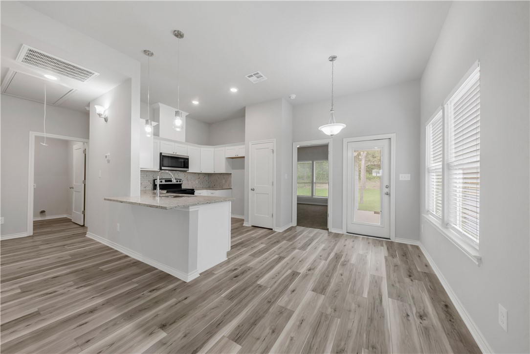 1803 Pin Oak Street Bryan, TX 77803 - Photo 4 of 17 a view of kitchen with refrigerator stove and wooden floor