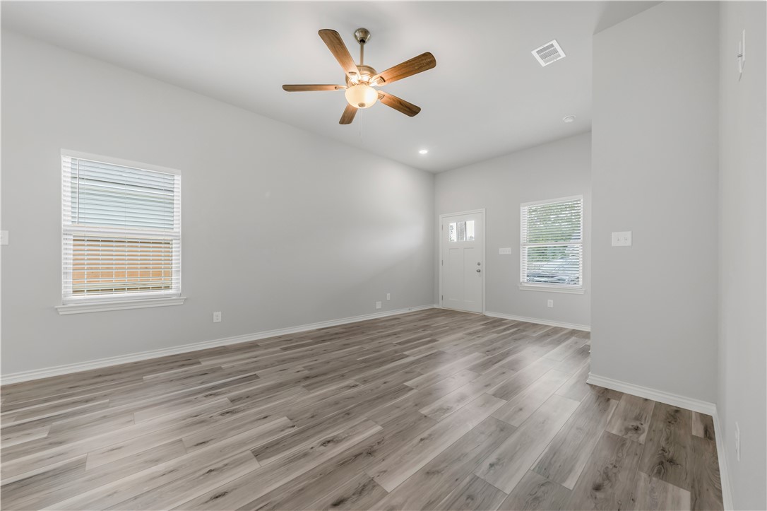 1803 Pin Oak Street Bryan, TX 77803 - Photo 6 of 17 an empty room with wooden floor fan and windows