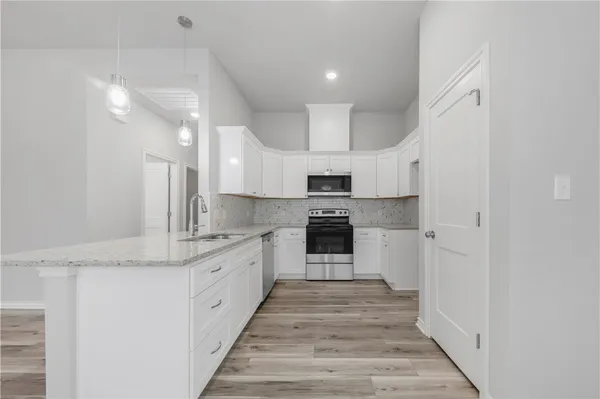 a large kitchen with stainless steel appliances granite countertop a stove and a sink