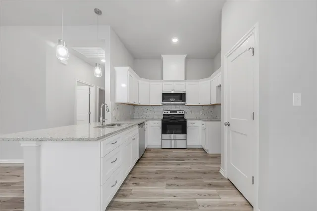 a large kitchen with stainless steel appliances granite countertop a stove and a sink
