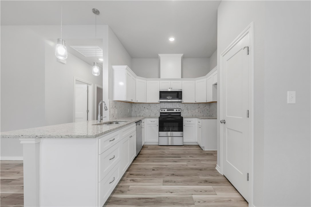 1803 Pin Oak Street Bryan, TX 77803 - Photo 7 of 17 a large kitchen with stainless steel appliances granite countertop a stove and a sink