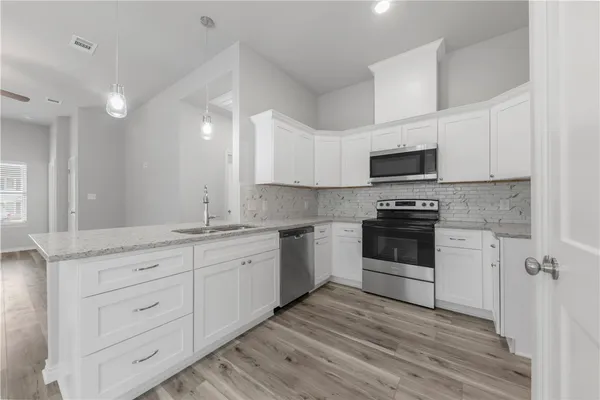 a kitchen with granite countertop white cabinets and white appliances