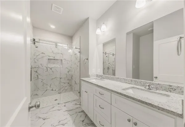 a bathroom with a granite countertop sink mirror and shower