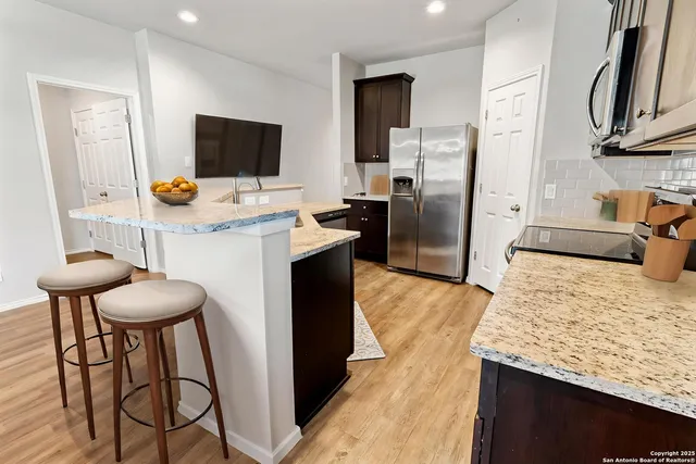 a kitchen with stainless steel appliances kitchen island a refrigerator and a stove top oven