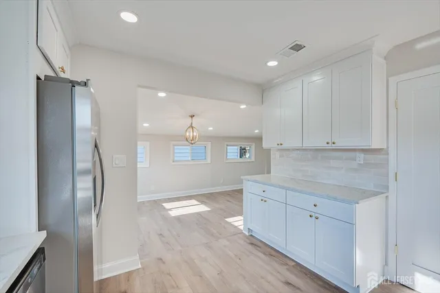 a large kitchen with cabinets stainless steel appliances and a counter space