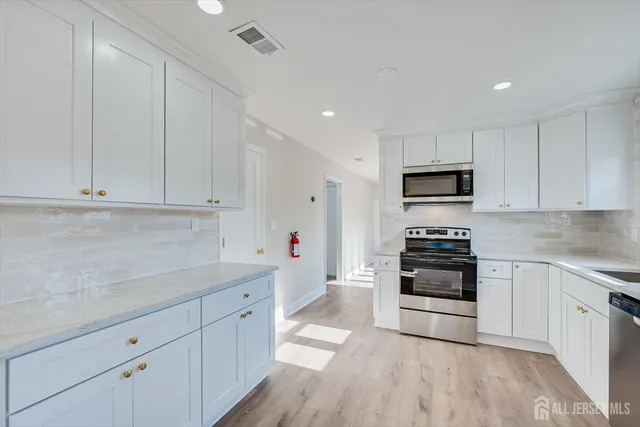 a view of a kitchen with marble kitchen and stainless steel appliances