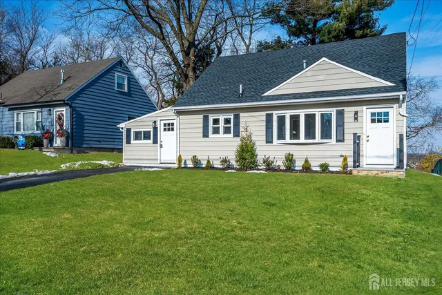a front view of a house with a yard and trees