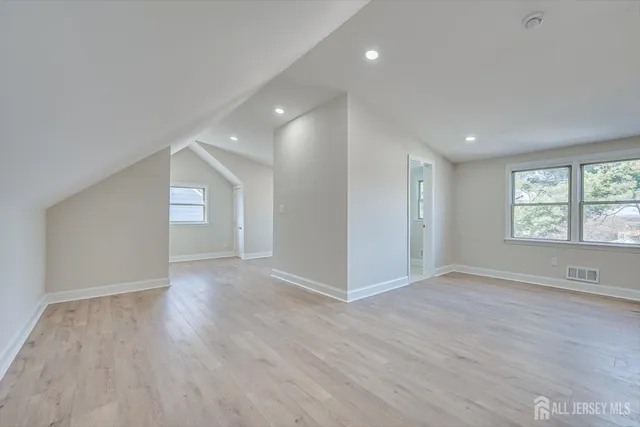 a view of empty room with wooden floor and window