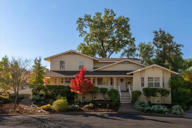 a front view of a house with a yard and potted plants