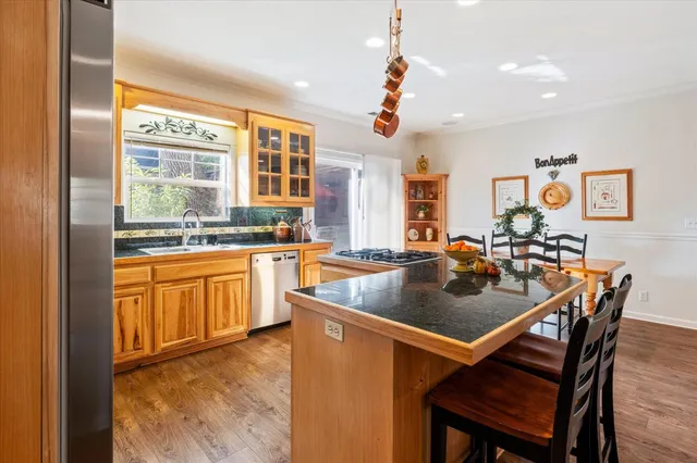 a kitchen with a stove a sink a dining table and chairs