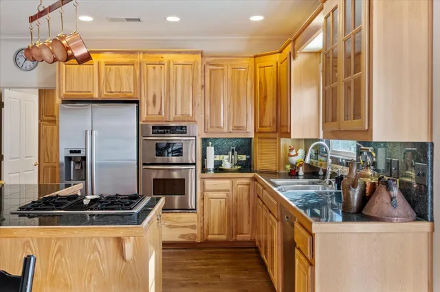 a kitchen with stainless steel appliances granite countertop a stove a sink and a refrigerator