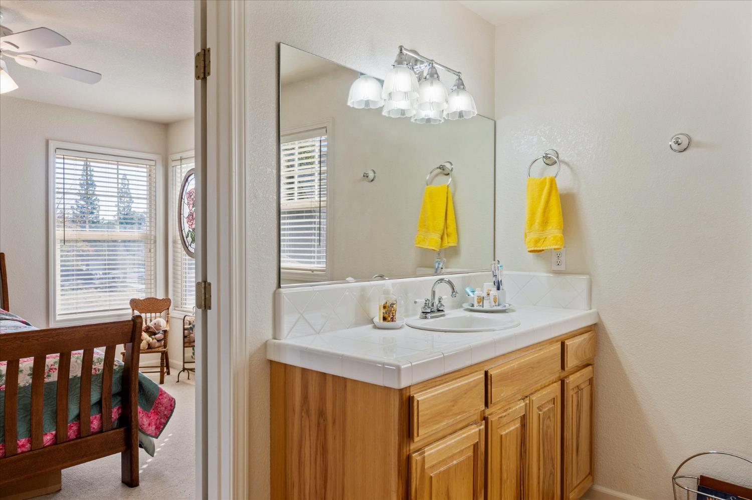 476 Fiddler Court Angels Camp, CA 95222 - Photo 27 of 40 a bathroom with a granite countertop sink and a mirror