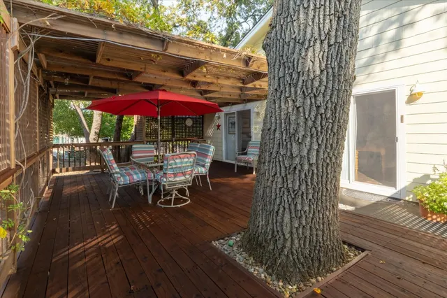 a view of a patio with table and chairs under an umbrella with wooden floor