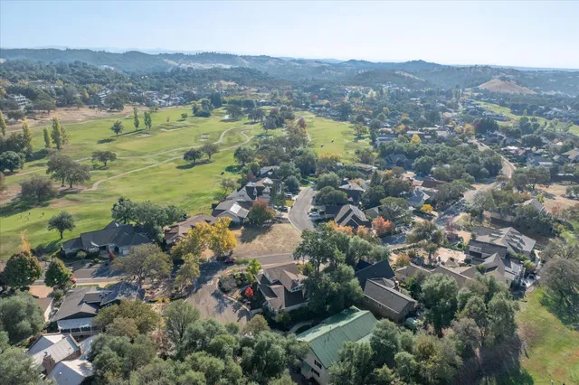 an aerial view of residential houses with outdoor space and trees