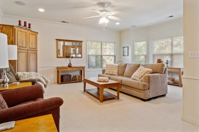 a living room with furniture ceiling fan and a window