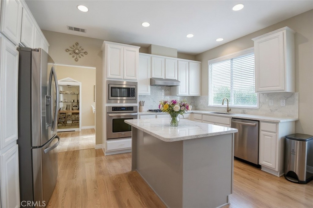 2621 Fallen Leaf Court Simi Valley, CA 93063 - Photo 21 of 58 a kitchen with stainless steel appliances granite countertop a refrigerator a sink dishwasher a oven with white cabinets and wooden floor