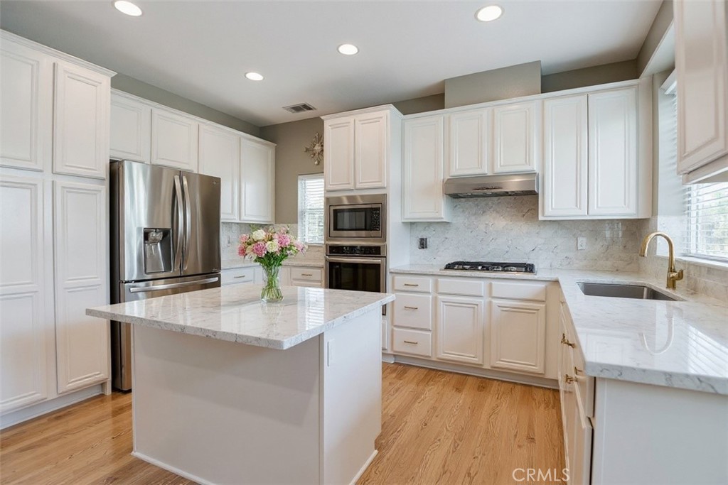 2621 Fallen Leaf Court Simi Valley, CA 93063 - Photo 23 of 58 a kitchen with kitchen island granite countertop appliances cabinets and a counter top space