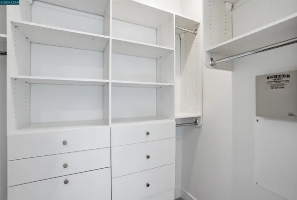 a view of walk in closet with empty racks