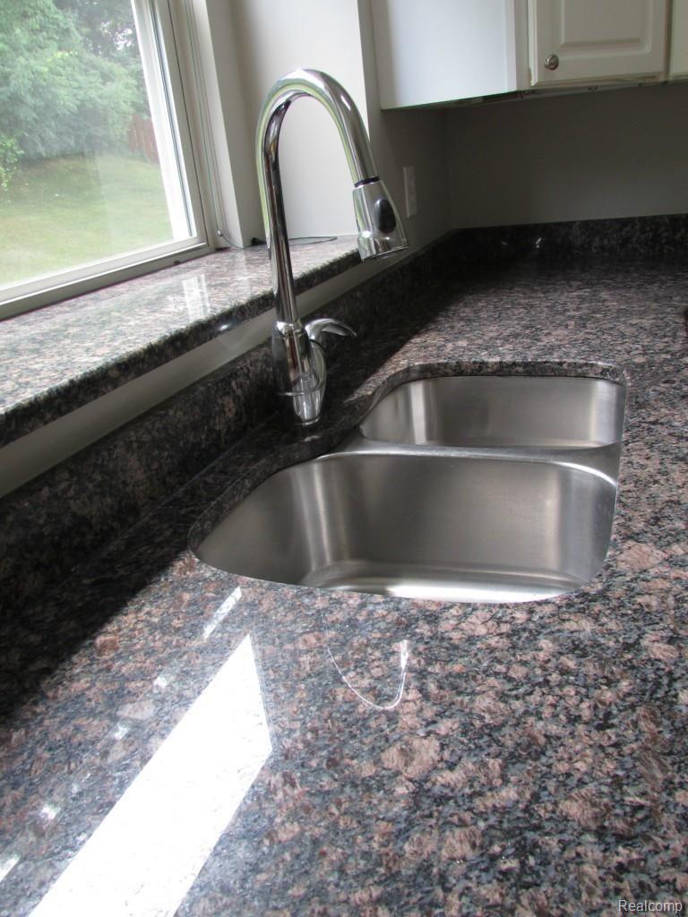 46 Eagle Ridge Road Lake Orion, MI 48360 - Photo 4 of 35 Kitchen features granite counter tops, granite window ledge, under mount sink and upgraded kitchen faucet