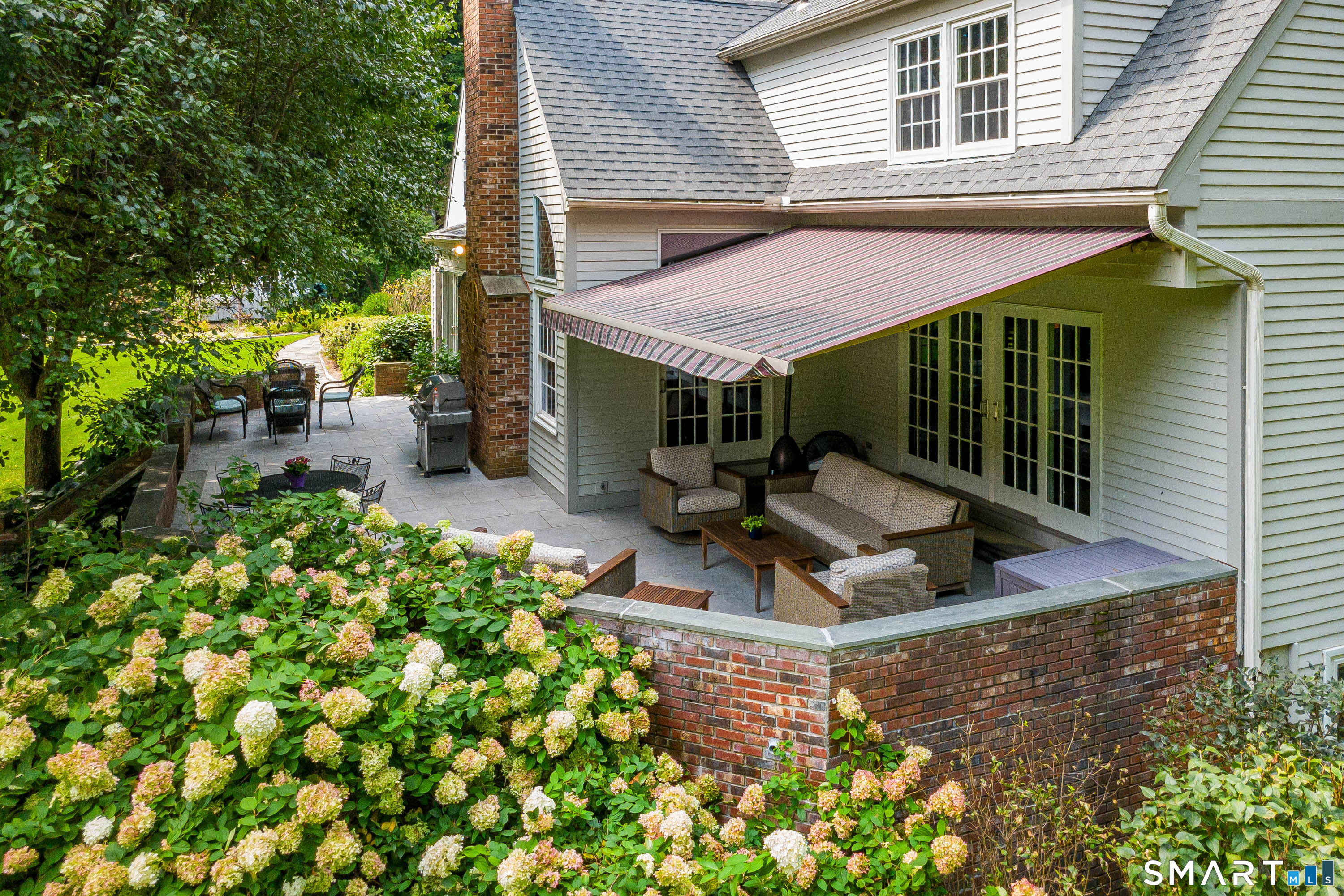 16 Winding Brook Road Newtown, CT 06470 - Photo 31 of 39 Spacious rear patio with retractable awning, multiple seating areas and beautiful hydrangea plantings.