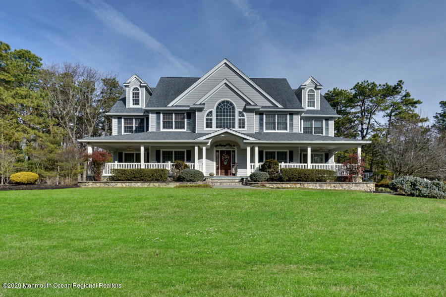 a front view of a house with garden and trees