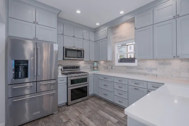 a kitchen with granite countertop stainless steel appliances and wooden cabinets