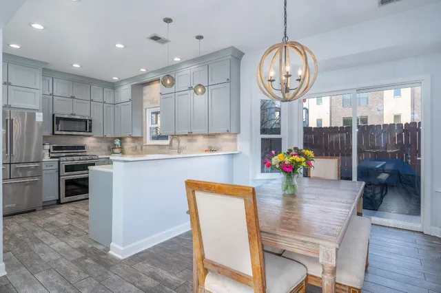 a very nice looking kitchen with a large window wooden cabinets and stainless steel appliances