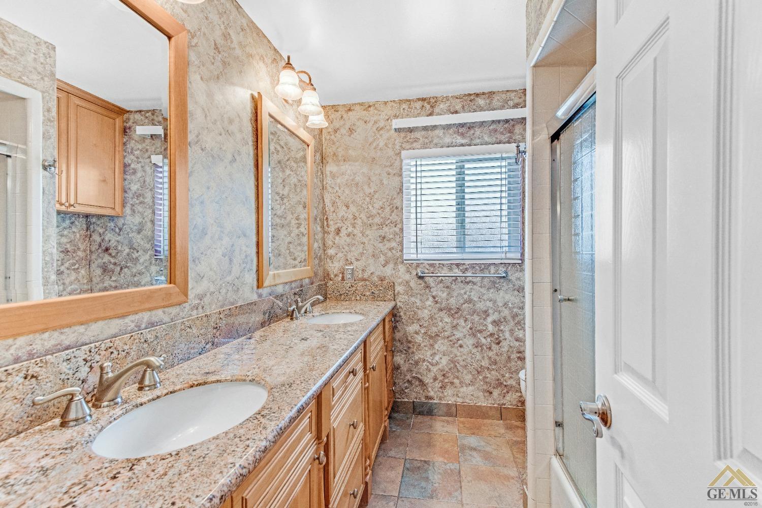 Undisclosed Address Bakersfield, CA 93311 - Photo 13 of 50 a bathroom with a granite countertop sink and a mirror