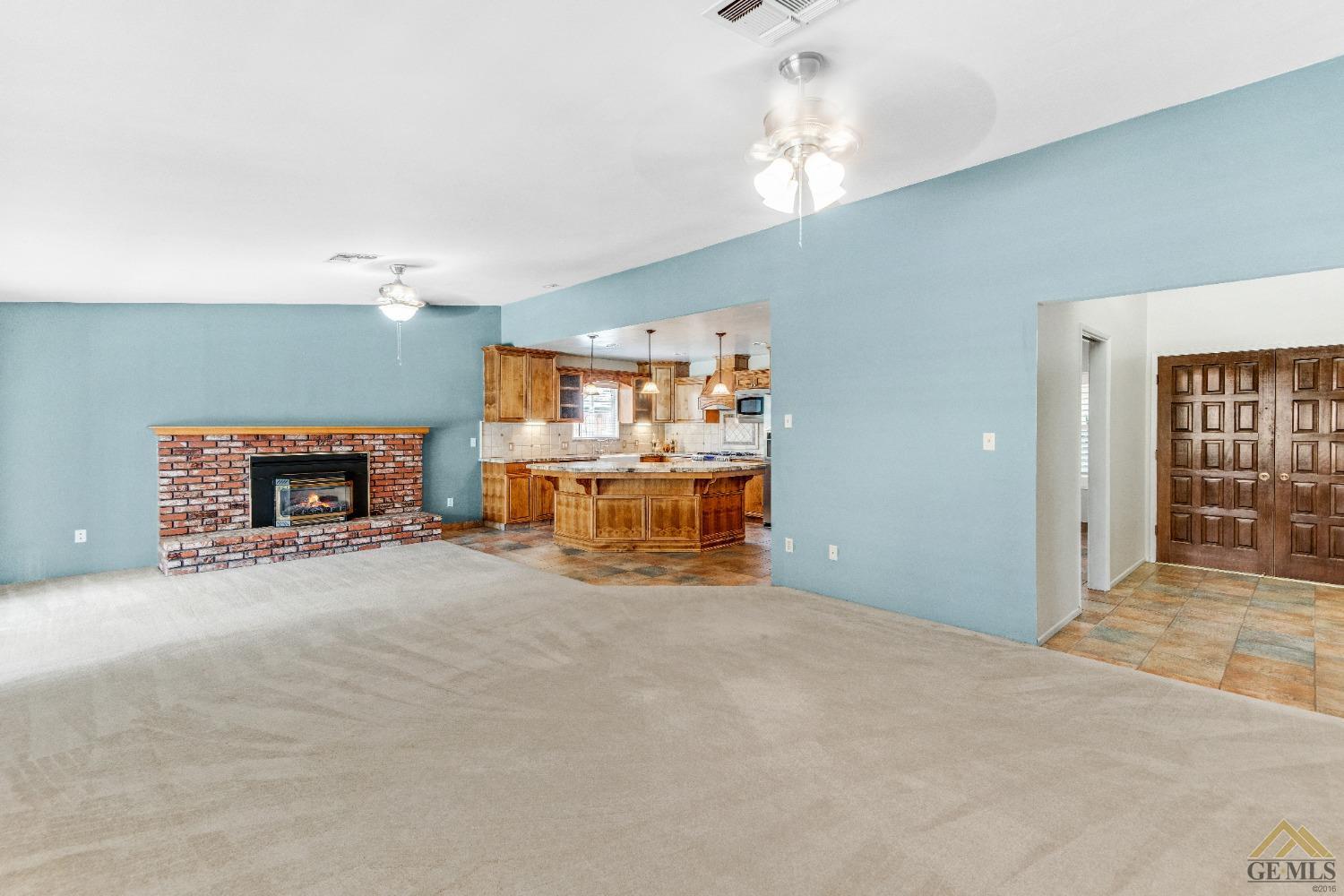 Undisclosed Address Bakersfield, CA 93311 - Photo 21 of 50 a room with a fireplace and chandelier