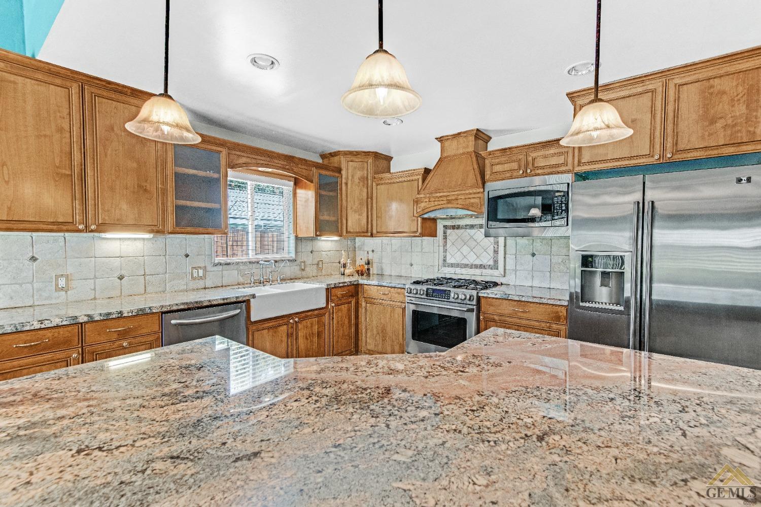 Undisclosed Address Bakersfield, CA 93311 - Photo 25 of 50 a large kitchen with kitchen island a sink stove and refrigerator