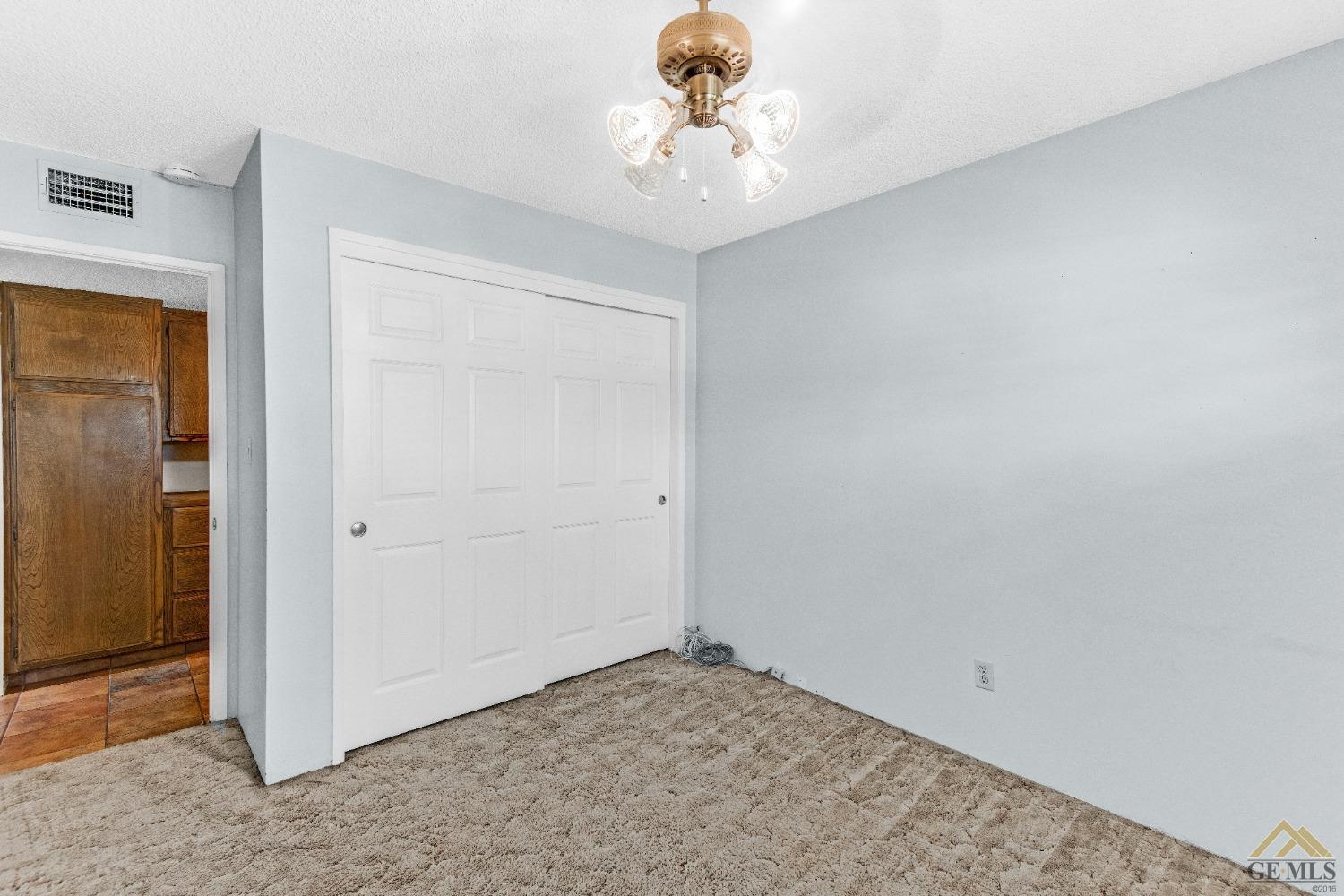 Undisclosed Address Bakersfield, CA 93311 - Photo 6 of 50 an empty room with a chandelier fan and closet
