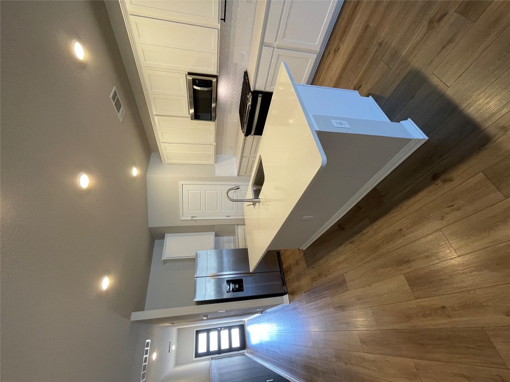 105 Sungrove Trail Georgetown, TX 78628 - Photo 4 of 18 a kitchen with stainless steel appliances kitchen island granite countertop a sink a stove and a wooden floors