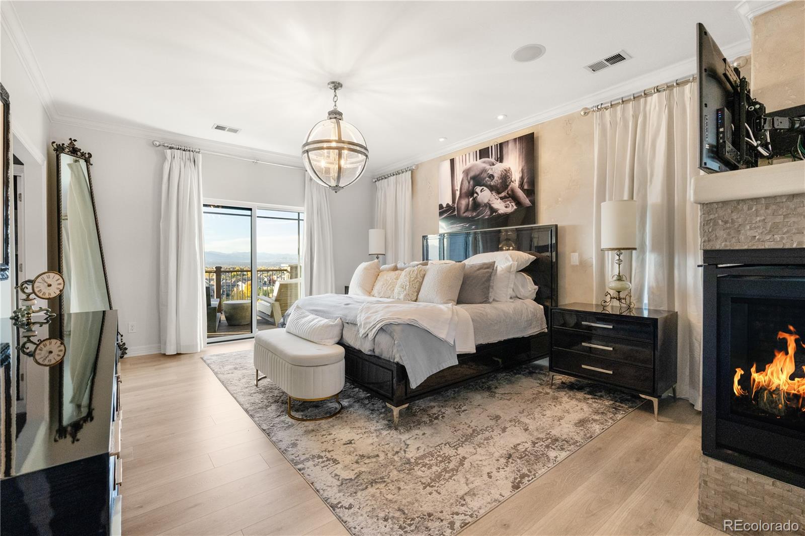 10785 Sundial Rim Road Highlands Ranch, CO 80126 - Photo 14 of 43 a bed room with a bed a couch and a flat tv screen