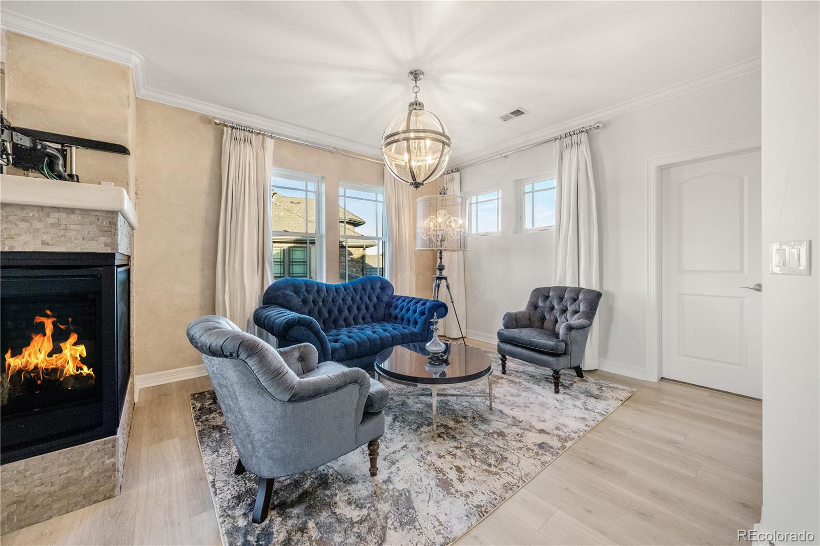 10785 Sundial Rim Road Highlands Ranch, CO 80126 - Photo 20 of 43 a living room with furniture a fireplace and a flat screen tv