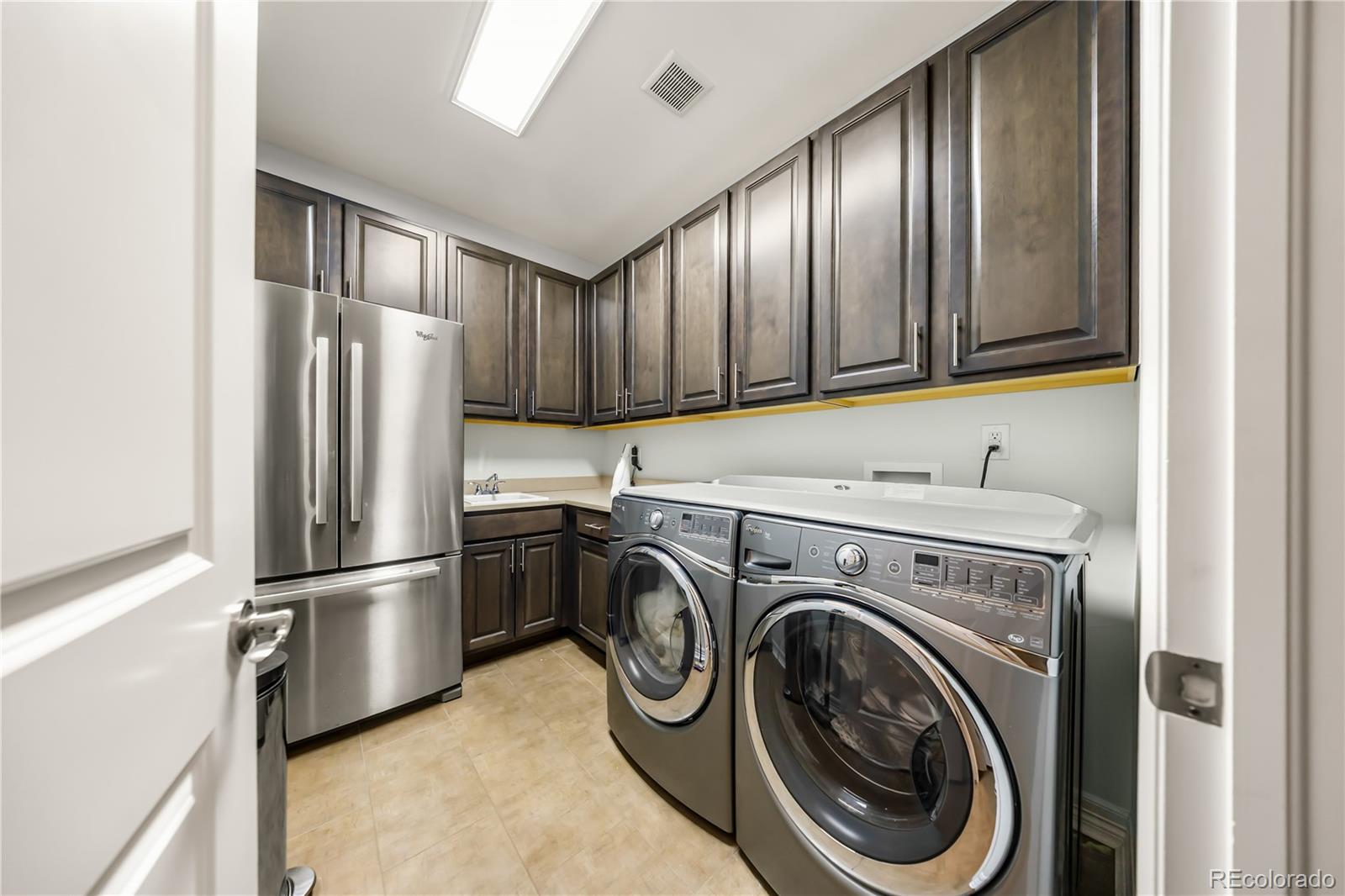 10785 Sundial Rim Road Highlands Ranch, CO 80126 - Photo 40 of 43 a kitchen with refrigerator cabinets and washer