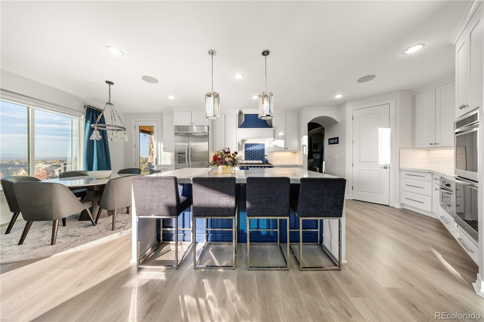10785 Sundial Rim Road Highlands Ranch, CO 80126 - Photo 9 of 43 a dining hall with stainless steel appliances kitchen island granite countertop a table chairs and a living room