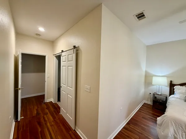 a view of a bedroom with a bed and wooden floor