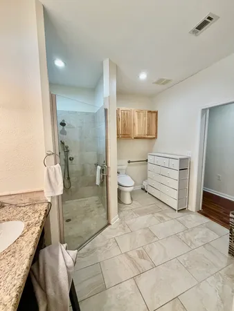 a bathroom with a granite countertop sink and a toilet