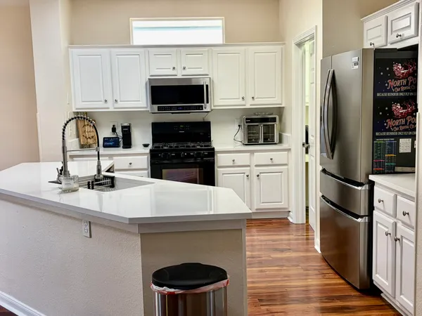 a kitchen with stainless steel appliances a stove refrigerator sink and microwave