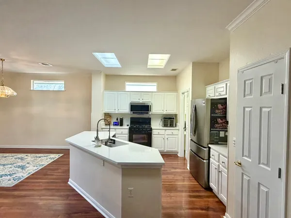a kitchen with stainless steel appliances a refrigerator and a stove top oven
