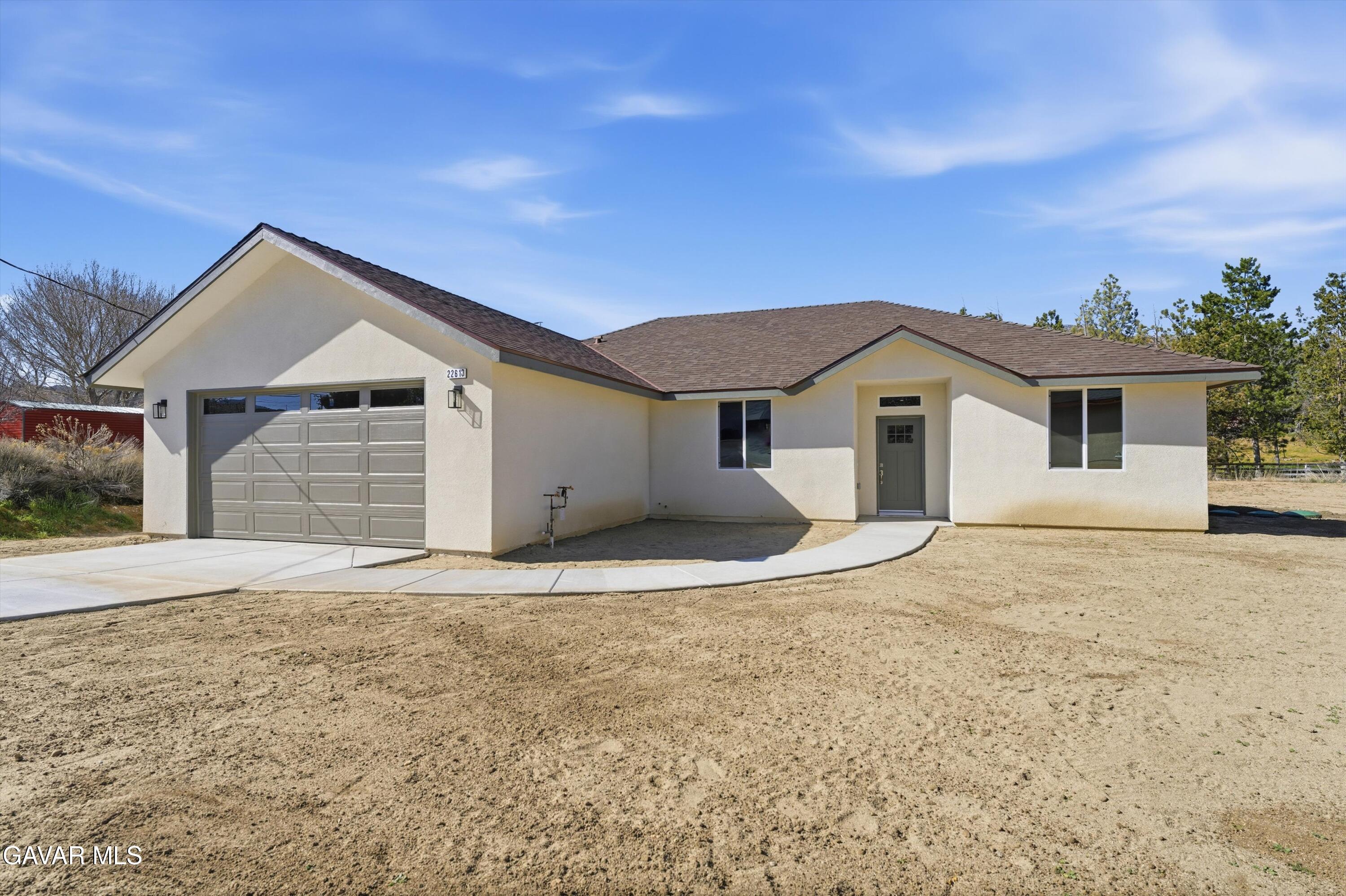 22613 Royal Place Tehachapi, CA 93561 - Photo 2 of 28 a front view of a house with a yard and garage