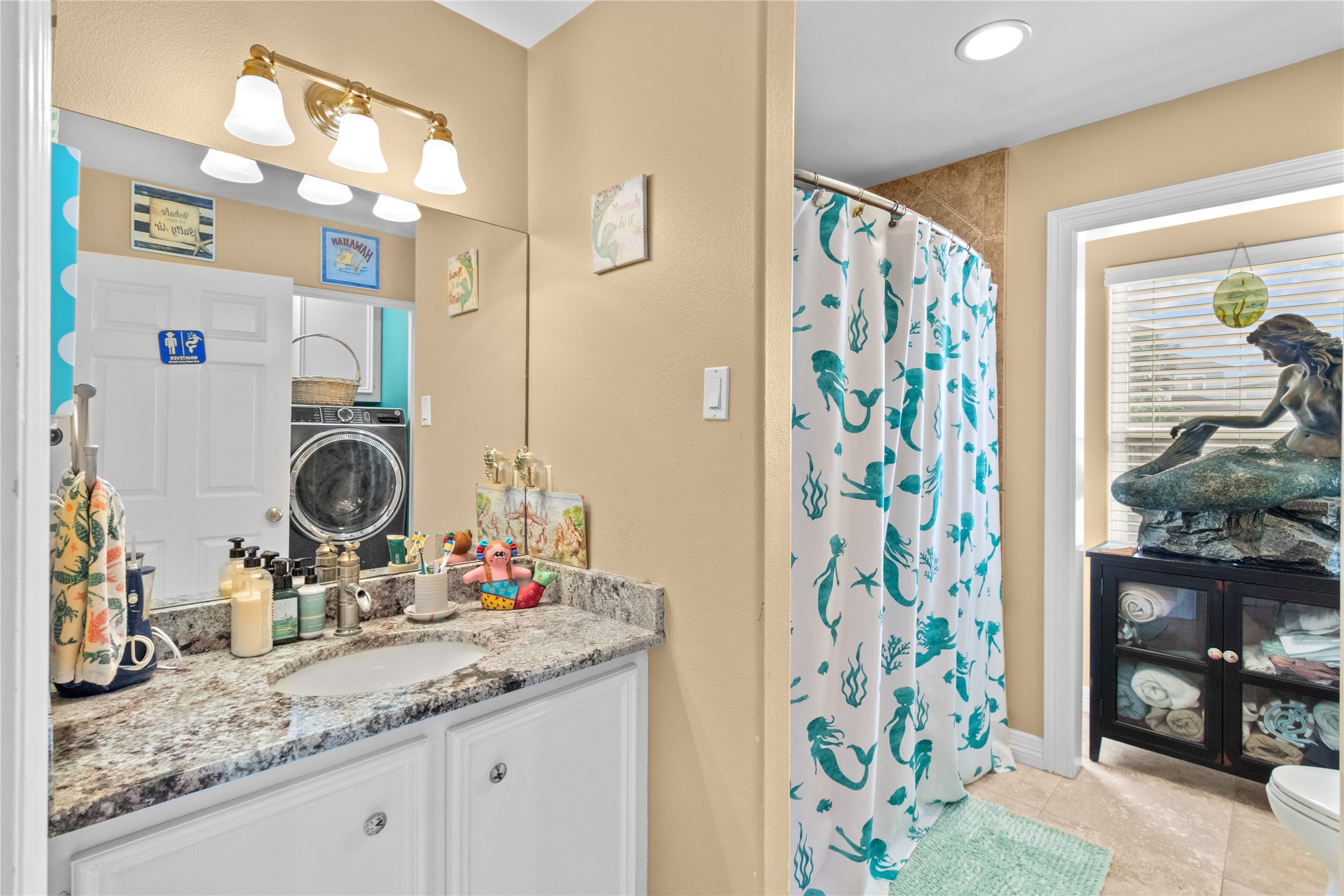 106 Isles End Road Tiki Island, TX 77554 - Photo 6 of 44 a bathroom with a granite countertop sink a potted plant and a shower curtain