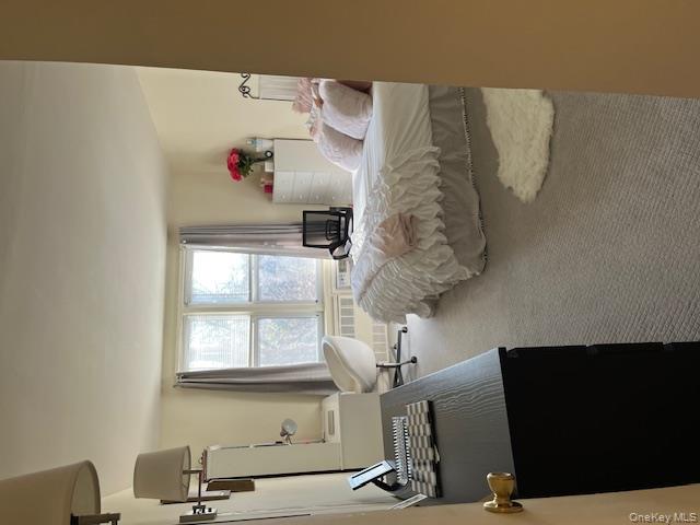 241-20 Northern Boulevard, Unit 3H Queens, NY 11362 - Photo 12 of 16 a bedroom with a bed and a window