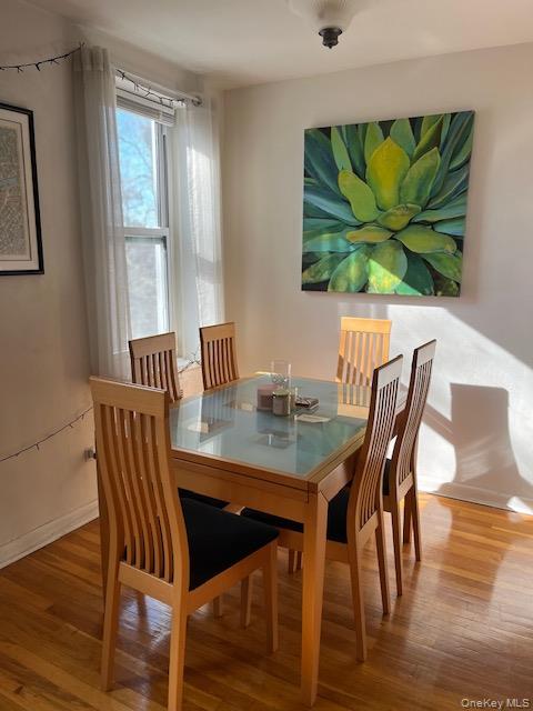 241-20 Northern Boulevard, Unit 3H Queens, NY 11362 - Photo 3 of 16 a dining room with furniture potted plants and wooden floor