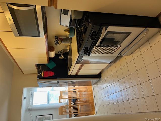 241-20 Northern Boulevard, Unit 3H Queens, NY 11362 - Photo 4 of 16 a kitchen with stainless steel appliances granite countertop a stove and a refrigerator