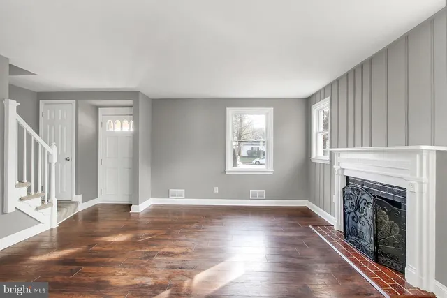 a view of empty room with fireplace and wooden floor